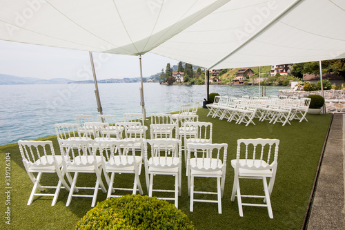 Outdoor preparation for event, white chairs on yard