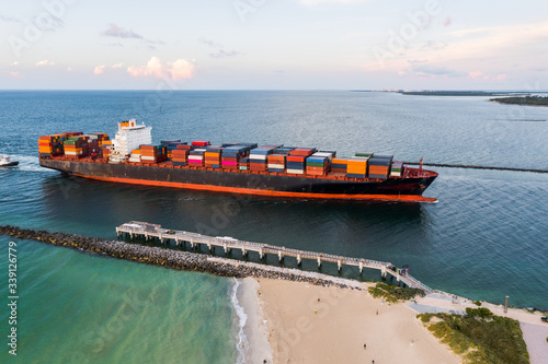 Aerial of cargo ship with containers entering the port of Miami