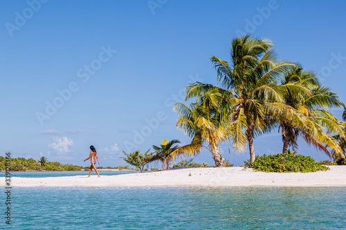 Woman walking on beach on tropical island, Polynesia photo