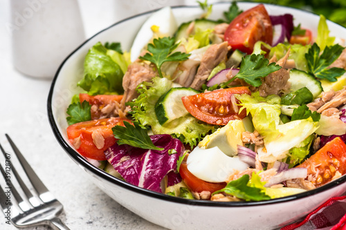 Tuna salad with green leaves, eggs and vegetables.