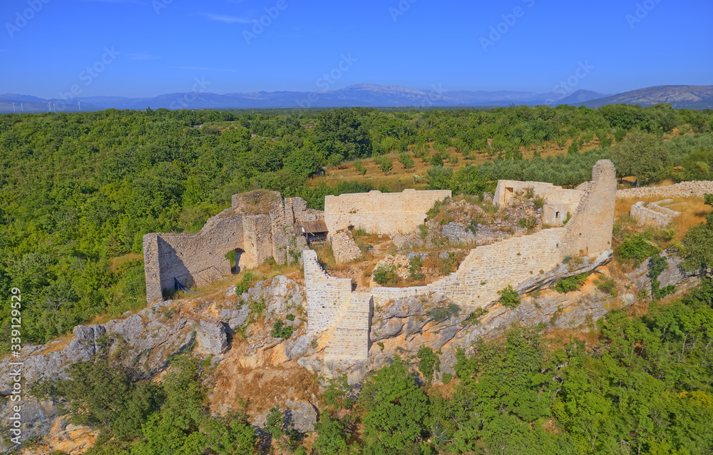 Drone aerial view of the archaeological remains of the medieval fort Necven, located on the west side of mountain Promina on top of the canyon of the river Krka in Croatia in Promina County.
