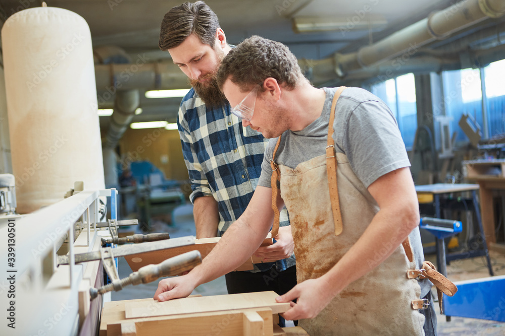 Apprentice and instructor build a wooden shelf Apprentice and instructor build a wooden shelf