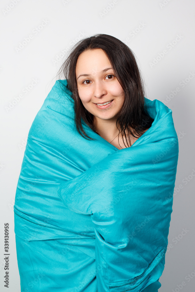 A happy young girl wrapped up in a blue blanket. A happy young girl wrapped up in a blue blanket.