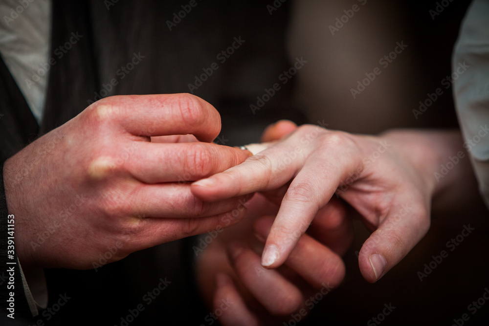 An unrecognizable bride and groom exchanging of the Wedding Rings in church during the christian wedding ceremony 