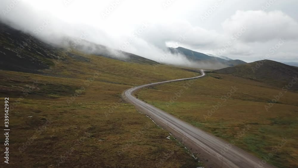 Two hitchhikers in the stormy weather of the Dempster Highway in Northern Yukon Two hitchhikers in the stormy weather of the Dempster Highway in Northern Yukon