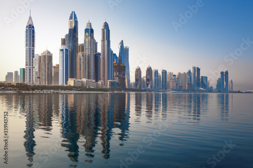 Modern and Luxury Dubai Marina with reflection - famous Jumeirah beach at sunrise, United Arab Emirates