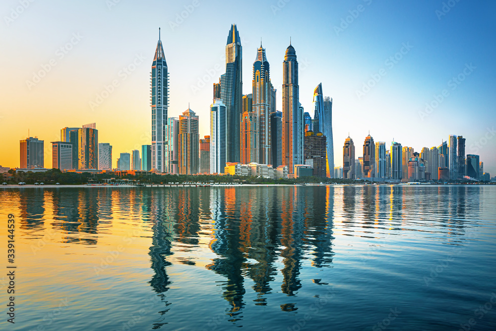 Modern and Luxury Dubai Marina with reflection - famous Jumeirah beach at sunrise, United Arab Emirates