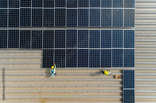 top view worker installing a solar cell on the factory roof. photo