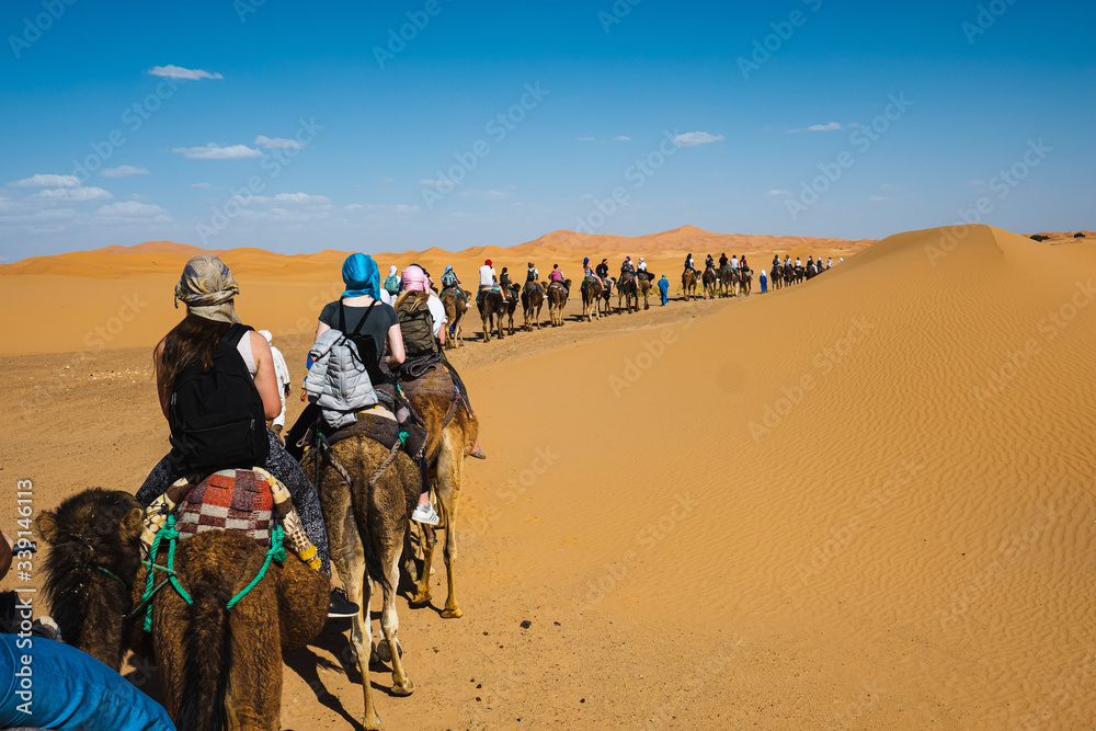 People riding camel in the Sahara desert, Morocco.