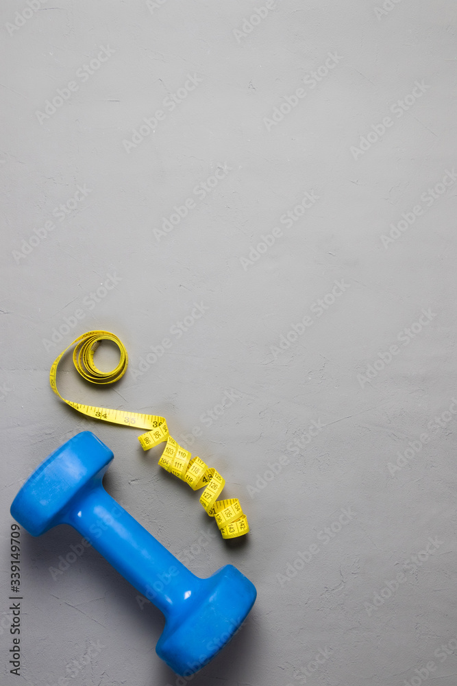 dumbbell and centimeter on a light background dumbbell and centimeter on a light background