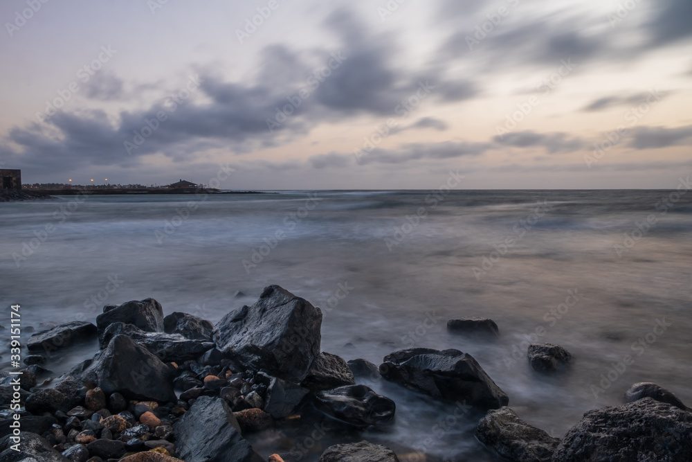 Waves on the Atlantic Ocean at sunrise. Caleta de La Guirra Beach, Fuerteventura, Canary islands, Spain. October 2019. Long exposure shot. Waves on the Atlantic Ocean at sunrise. Caleta de La Guirra Beach, Fuerteventura, Canary islands, Spain. October 2019. Long exposure shot.