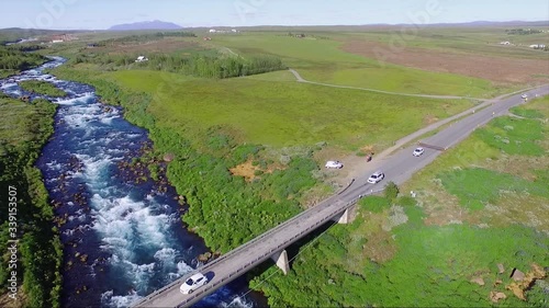 Aerial, drone shot over traffic on on road 35, the Biskupstungnabraut bridge, at the Tungufljot river, sunny day, in southwestern Iceland photo