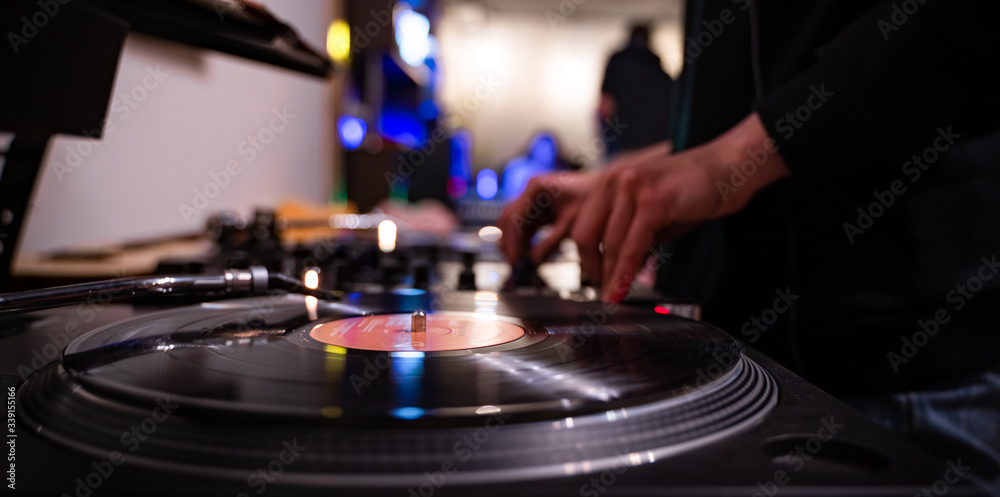 Party dj plays music at hip hop concert on turntables vinyl record player & sound mixer. Scratching vinyls records.Retro djs stage equipment on party stage. Moscow