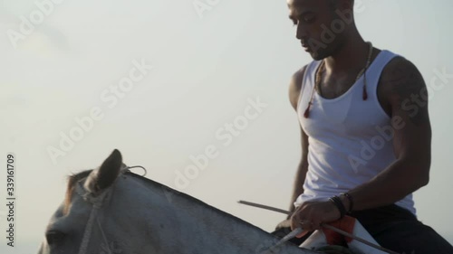 Good looking man riding a horse on an African beach
