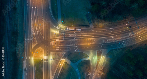 Aerial top down view on the crossroad junction with the geometric lane patterns, traffic lights and street lamps illuminating the scene