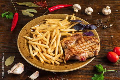 steak and french fries on the wooden background photo