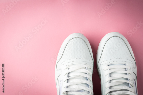 White sneakers on pink background.