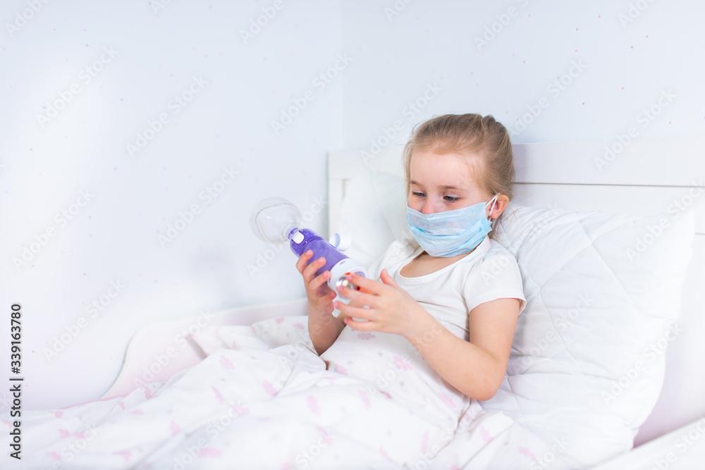 Sick little girl with asthma medicine lying in bed. Unwell kid with chamber inhaler for cough treatment. Flu season. Bedroom or hospital room for young patient. Healthcare and medication.