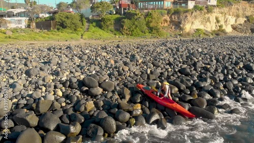 A kayaker preparing his kayak before entering the sea.