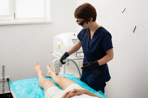 Cute woman in beauty studio getting laser hair removal procedure.