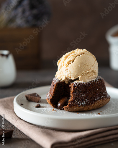 Canvastavla Chocolate lava cake with ice cream served on plate on dark background