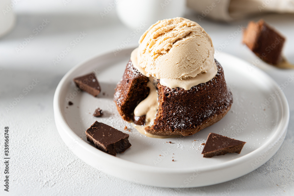 Chocolate lava cake with liquid centre on white moody background. Restaurant menu, recipe. Side view Chocolate lava cake with liquid centre on white moody background. Restaurant menu, recipe. Side view