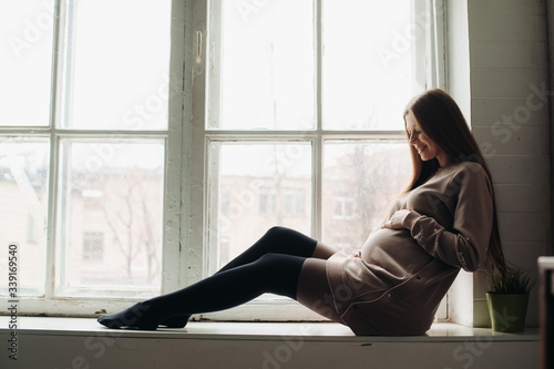 pregnant beautiful woman sitting by the window © Наталья Котковец
