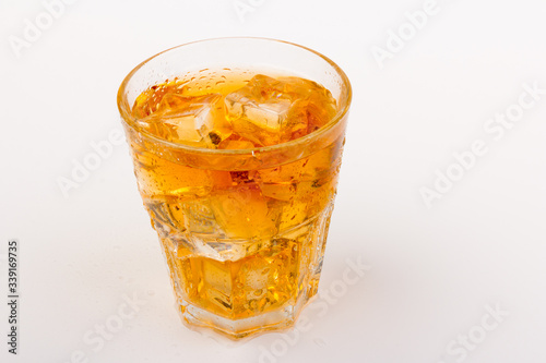 Glass of scotch whiskey and ice over white background.