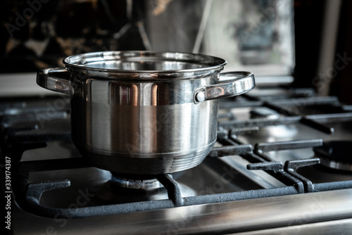 Stainless steel cooking pot on gas stove in kitchen. 