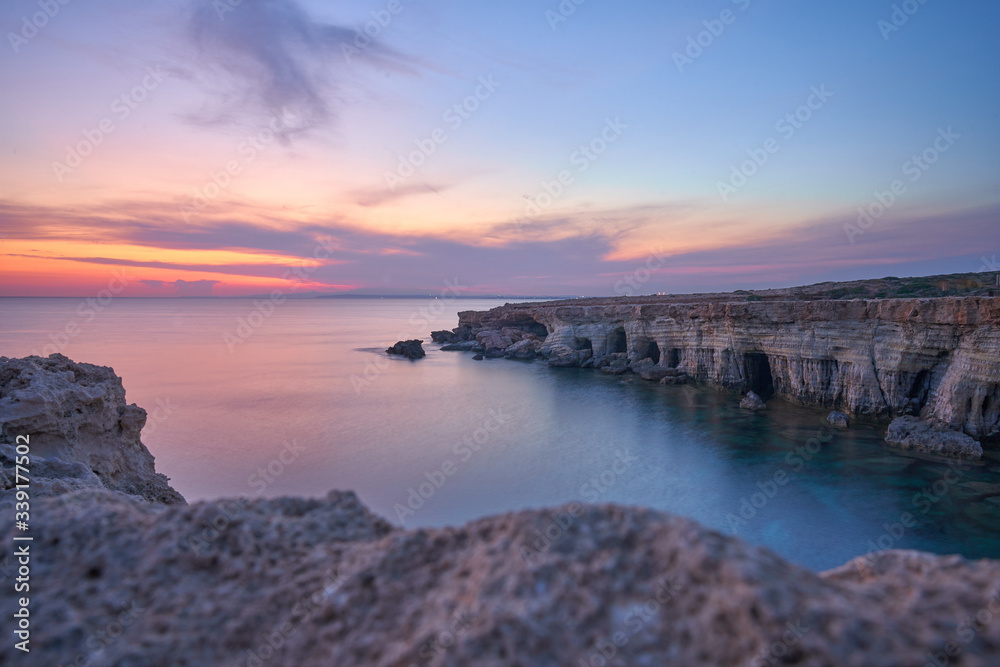 beautiful sunset with spectacular colours, a fantastic sky and an unobstructed view of the sea at the sea caves of Ayia Napa in the Cape Greco National Forest Park in Cyprus

