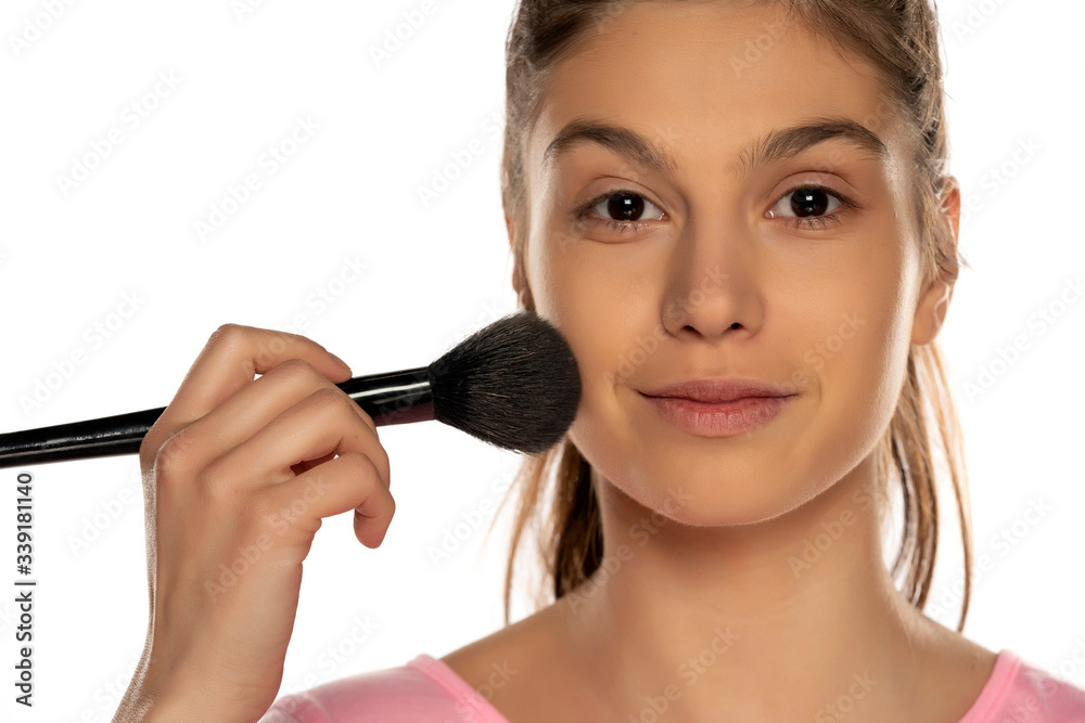 Portrait of young happy woman applying powder foundation with brush Portrait of young happy woman applying powder foundation with brush