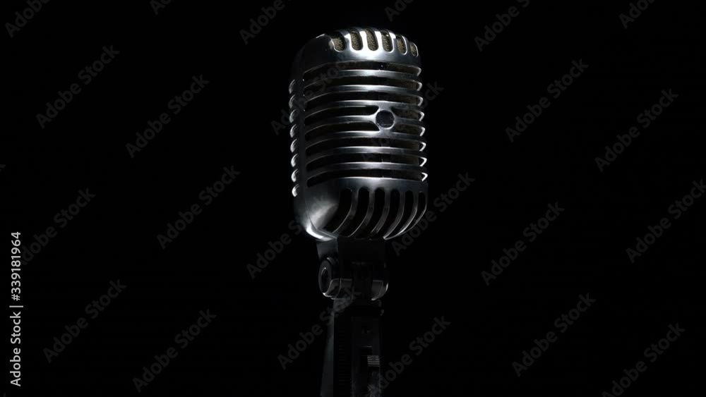 Retro microphone rotating on black background