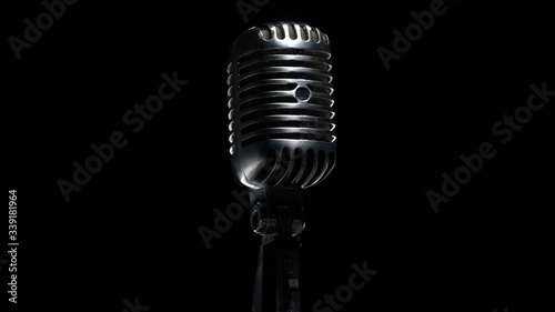 Retro microphone rotating on black background