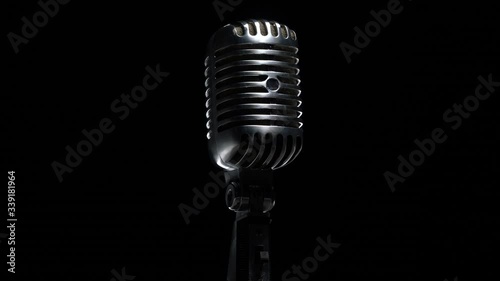 Retro microphone rotating on black background