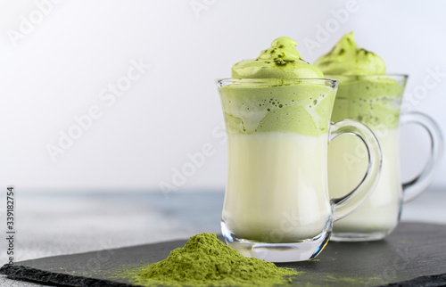 Two cups Dalgona Matcha Latte, a creamy whipped matcha, on light background. photo