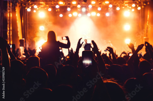 silhouettes of a heads and hands of a crowd of fans at a live concert