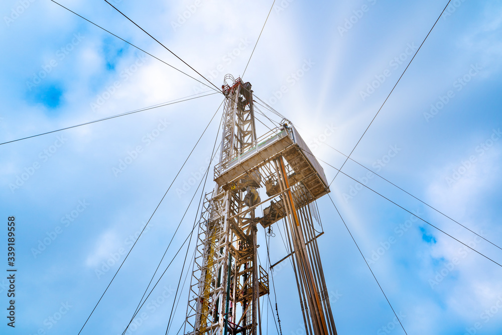 Oil and Gas Drilling Rig onshore dessert with dramatic cloudscape. Oil drilling rig operation on the oil platform in oil and gas industry. Oil and Gas Drilling Rig onshore dessert with dramatic cloudscape. Oil drilling rig operation on the oil platform in oil and gas industry.
