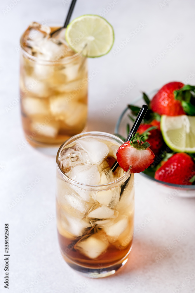 Glasses of Cold Citrus and Strawberry Ice Tea on Light Gray Background Decorated with Ripe Lime and Strawberry Healthy Symmer Beverage Refreshing Drink Above Glasses of Cold Citrus and Strawberry Ice Tea on Light Gray Background Decorated with Ripe Lime and Strawberry Healthy Symmer Beverage Refreshing Drink Above