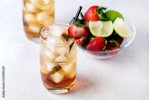 Glasses of Cold Citrus and Strawberry Ice Tea on Light Gray Background Decorated with Ripe Lime and Strawberry Healthy Symmer Beverage Refreshing Drink photo