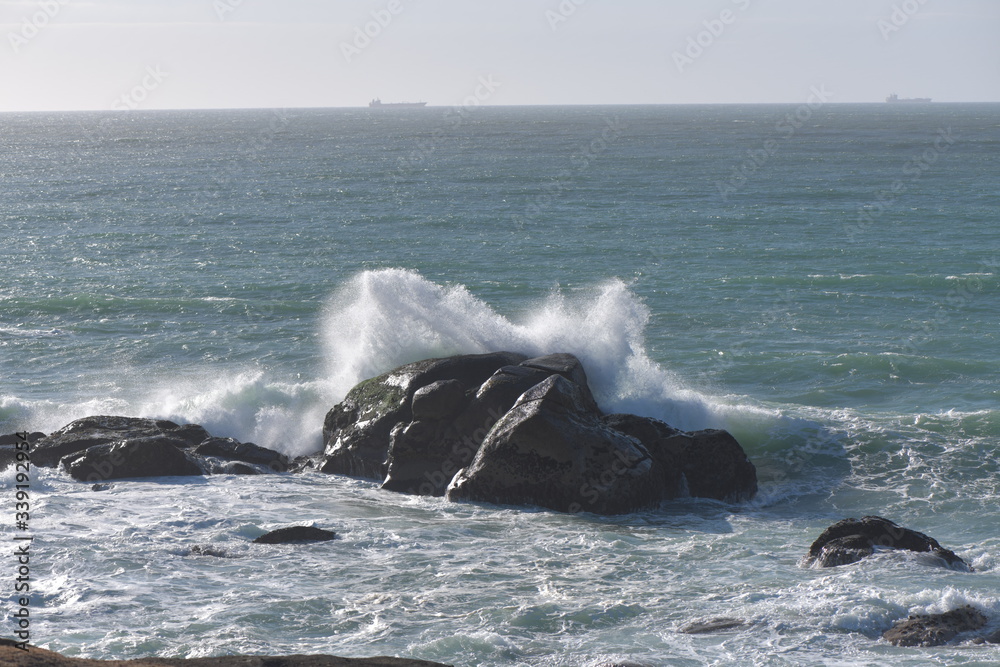Naklejka premium waves crashing on rocks