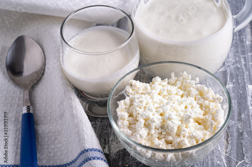 Fermented drink kefir in a glass and curd cheese in glass bowl. photo