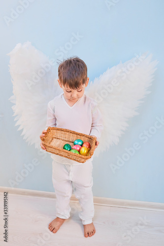 Angel boy in white with wing.Easter eggs