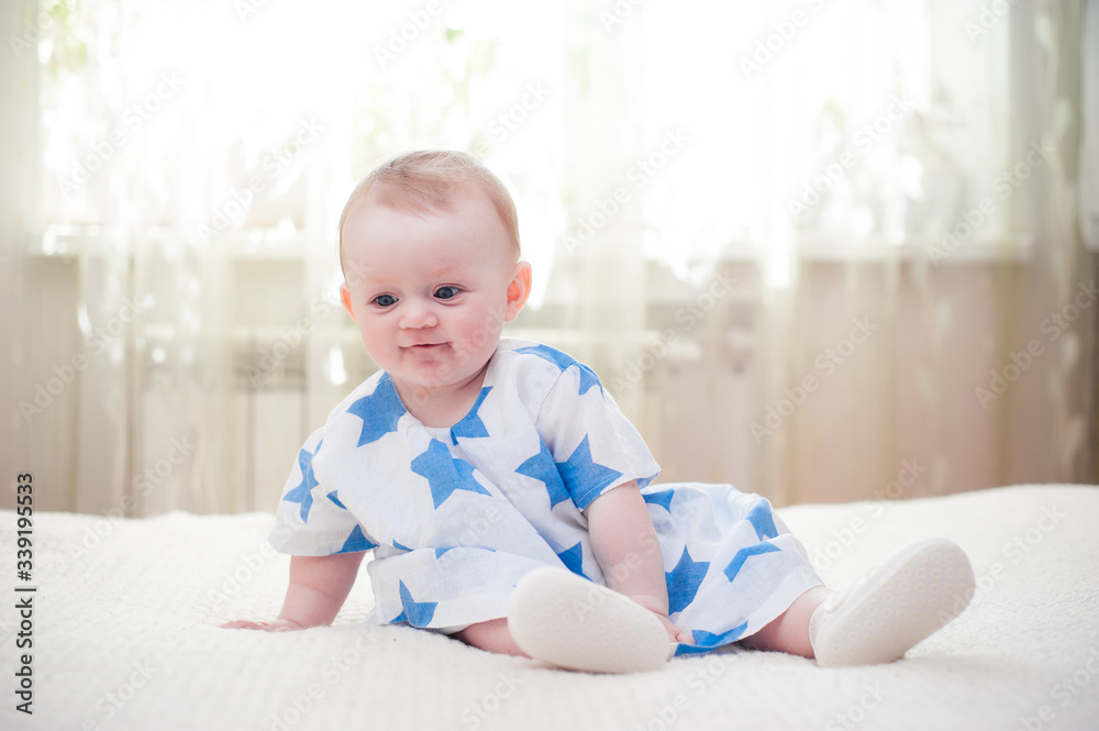 little girl 6 months old with big blue eyes in the house is happy little girl 6 months old with big blue eyes in the house is happy