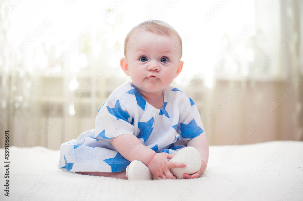 little girl 6 months old with big blue eyes in the house is happy little girl 6 months old with big blue eyes in the house is happy