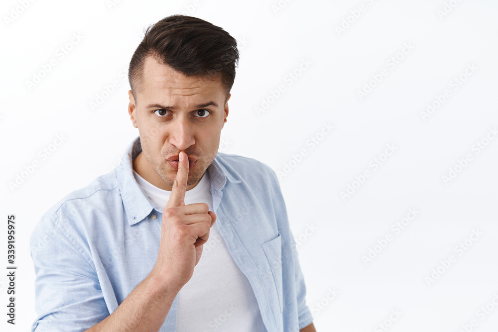 You better shut your mouth. Portrait of threatening serious pissed-off man, shushing at camera with index finger pressed to lips, frowning hush person be quiet, standing white background You better shut your mouth. Portrait of threatening serious pissed-off man, shushing at camera with index finger pressed to lips, frowning hush person be quiet, standing white background
