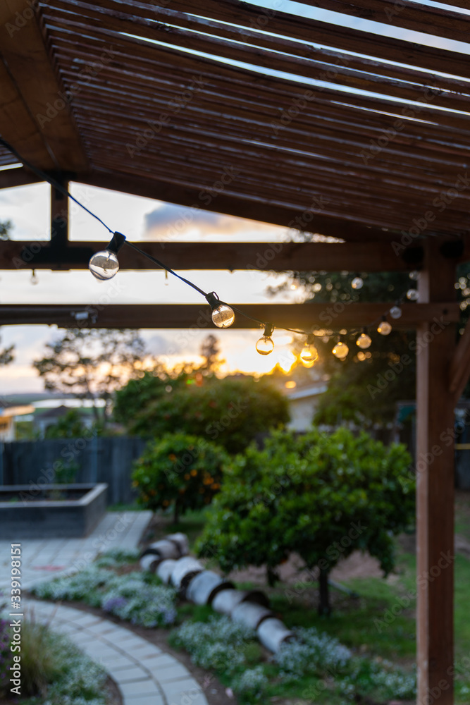 String lights under a pergola at sunset