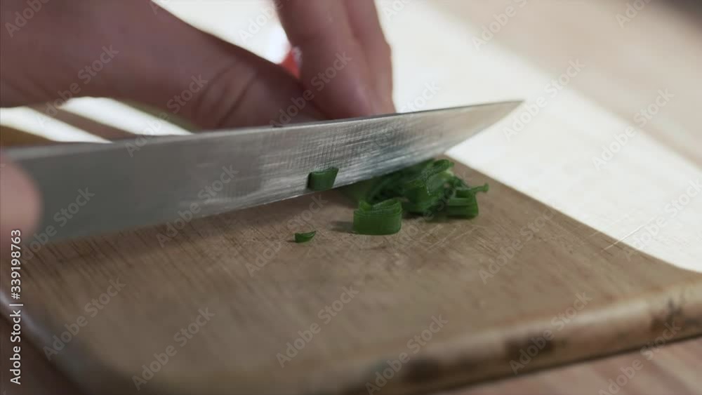 Woman cuts green onion on the kitchen Woman cuts green onion on the kitchen