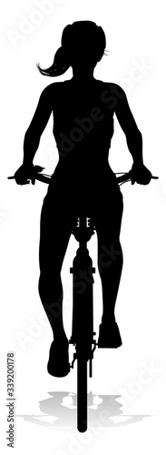 Bicyclist riding their bike and wearing a safety helmet in silhouette