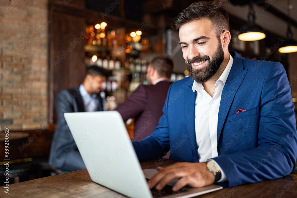 Handsome business man using laptop at his work break in restaurant Handsome business man using laptop at his work break in restaurant