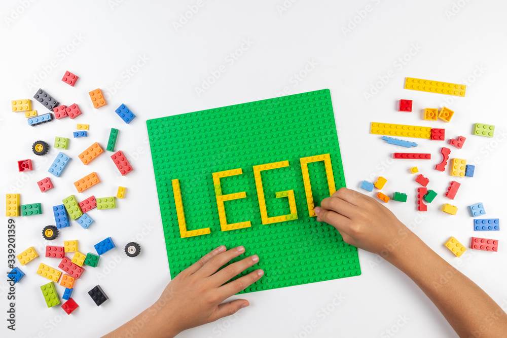 Vilnius, Lithuania - 17 August, 2019: Child hands make word LEGO on green  baseplate from colorful Lego blocks on white table Stock Photo | Adobe Stock
